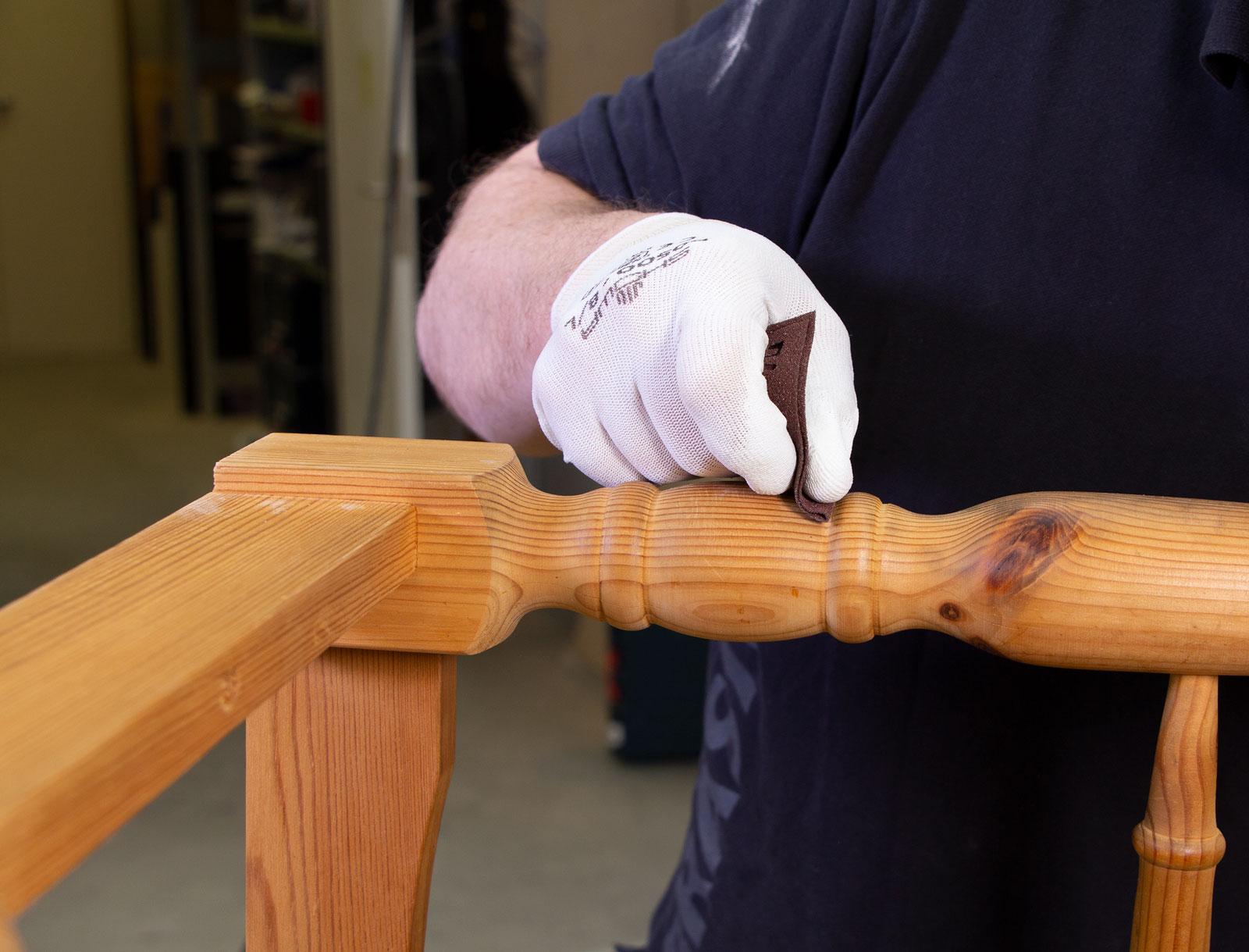 A picture of someone sanding a piece of wood with flexible sandpaper.